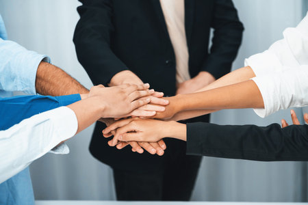 Group of diverse office worker join hand together in office room symbolize business synergy and...