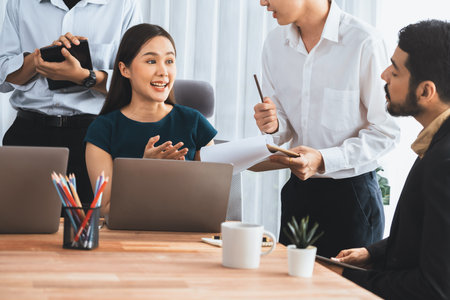 Professional Asian employee work together as team in corporate office, discussing business plans and data to achieve success on desk with laptop. Modern office worker teamwork concept. Concordの写真素材