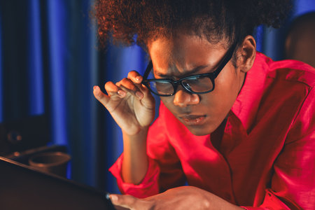 African woman businesswoman or blogger wearing pink shirt with serious face, looking and focusing on screen laptop with struggle project. Concept of stressful expression at work from home. Tastemaker.の写真素材