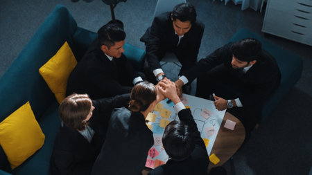 Top view of professional business team putting hands together and clapping hands to celebrate successful project while using mind mapping to brainstorm idea. Represented love and unity. Directorate.の写真素材