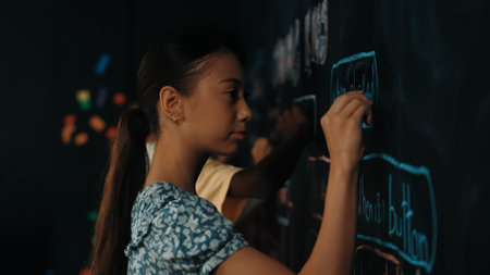 Panorama shot of adult writing engineering prompt on blackboard. Pretty smart student planing a project by using coding and programing system in STEM technology innovative class. Closeup. Edification.の写真素材
