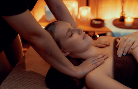 Caucasian woman customer enjoying relaxing anti-stress spa massage and pampering with beauty skin recreation leisure in warm candle lighting ambient salon spa at luxury resort or hotel. Quiescentの写真素材