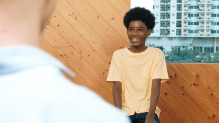 Smiling african boy sitting in circle while listening diverse friend sharing idea in group therapy...