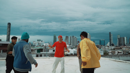 Closeup of street dancer wear colorful outfit while dance together. Group of attractive hipster dance and move to hip-hop music at skyscraper and city view. Break dance. Outdoor sport 2024. Endeavor.の写真素材