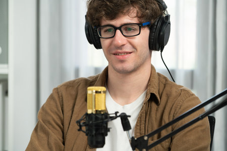 Host channel of influencer using headphone and mic talking with listeners on social media with laptop in life coaching and training marketing planning to customer target at studio office. Gusher.の写真素材