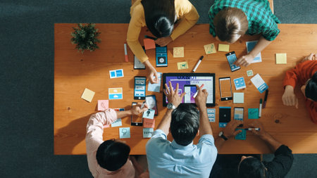 Top down view of business team writing idea on sticky note while planing for Ux Ui design for mobile...