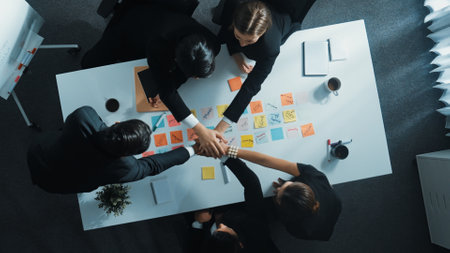 Top down aerial view of skilled investor team working together and putting hand together with...