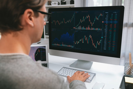 Business trader using computer and laptop to search highest profit value of dynamic increased stock...