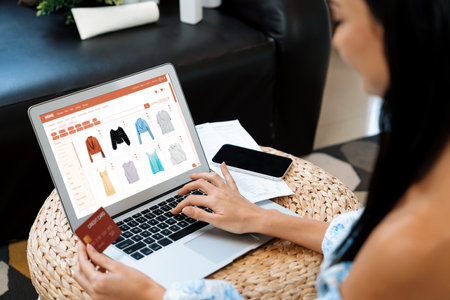 Young woman order or purchase product on internet using laptop and make transaction payment by smartphone. Online shopping lifestyle with credit card via internet banking on mobile application. Blitheの写真素材