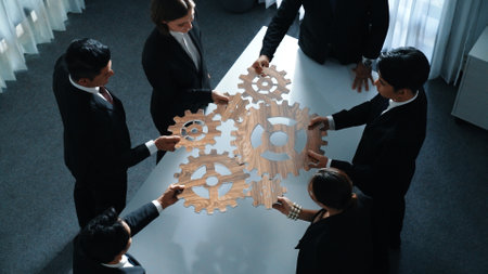 Top view of business people gather wooden cog together at meeting. Group of project manager helping and team working to solve problem at meeting room or workplace. Represent unity. Directorate.の写真素材