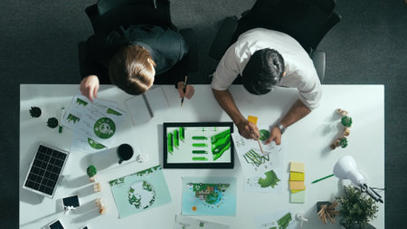 Top down view of business man presenting sustainable idea to manager by using tablet display ESG environmental social governance. Manager working together planning to use clean energy. Alimentation.の写真素材