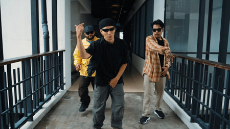 Group of smart hipster walking at modern bridge while pose at camera. Attractive handsome street dancer group looking at camera while dancing. Active, cool. Outdoor sport 2024. Endeavor.の写真素材