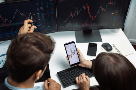 Top view focusing on phone discussing dynamic stock market in two business traders online website...