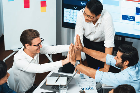 Happy office worker and project manager celebrate in meeting room after successfully achieving...