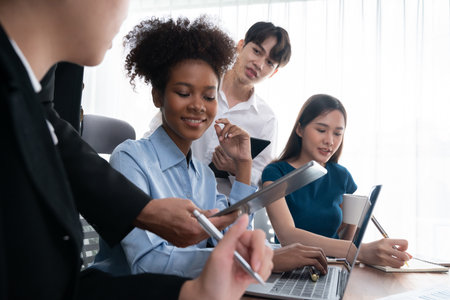 Happy diverse business people work together, discussing in corporate office. Professional and diversity teamwork discuss business plan on desk with laptop. Modern multicultural office worker. Concordの写真素材