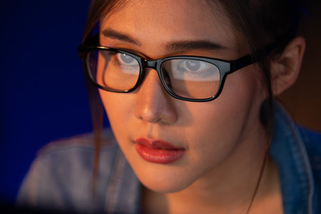 Portrait young beautiful Asian creative with glasses of serious face looking on pc to search project creator social media online, planning strategy creator at neon modern office at night. Stratagem.の写真素材