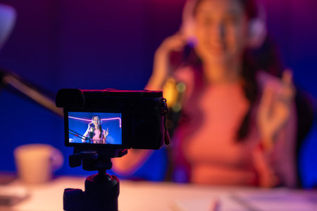 Selective focus camera screen in host channel of beautiful Asian listening the music on social media...