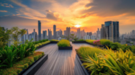 This blurred image captures the essence of a sunset over a city skyline, viewed from a lush rooftop...