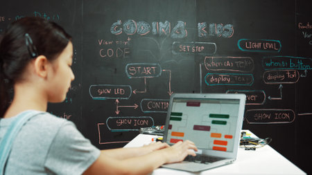 Young happy asian girl coding and programing prompt at blackboard. Highschool student using laptop...