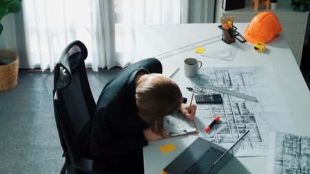 Top view of smart civil engineer drawing and measuring blueprint by using ruler. Aerial view of architect scatch building project plan at meeting table with equipment and safety helmet. Alimentation.の写真素材