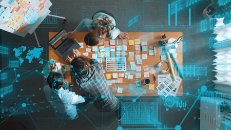 Top down view of business team with casual outfit looking laptop screen and sharing idea. Aerial...