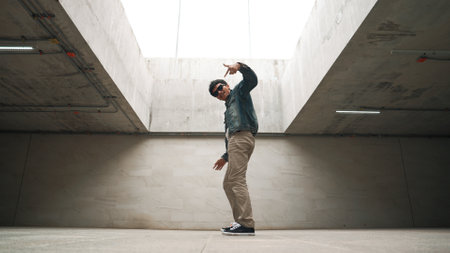 Stylish happy hipster perform break dance or freestyle foot step in building. Professional break dancer practice b-boy dance while wear stylish cloth. Modern lifestyle. Outdoor sport 2024. Sprightly.の写真素材