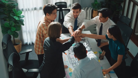 Top down aerial view of team putting hand together and cheering and encouraging team at meeting table with blueprint and architectural model. manager applause to successful project. Alimentation.の写真素材