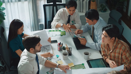Group of diverse team planning strategy while sitting at table with project plan. Top aerial view of smart business people working together to brainstorm and design house construction. Alimentation.の写真素材