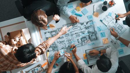 Top aerial view of project manager or civil engineer writing at blueprint and planning building design. Aerial view of architect working together at meeting table with document placed. Alimentation.の写真素材