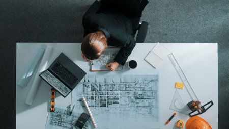 Architect engineer working while working on laptop with sticky notes and calculator to design...