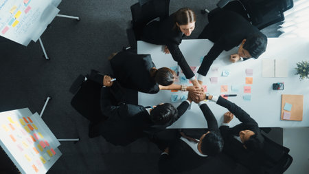 Top down aerial view of professional investor team putting hand together. Skilled diverse business team to celebrate successful project at meeting table with sticky note. Love and unity. Directorate.の写真素材