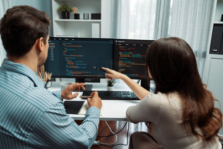 Team skilled developers program coding discussing creative website planning software project on two screen monitors full stack data analyzing design at office with back side view concept. Postulate.の写真素材