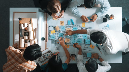 Top aerial view of project manager or civil engineer writing at blueprint and planning building...