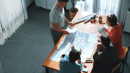 Top view of interior designer planing building while project manager working and holding coffee....