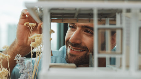 Closeup of young caucasian skilled architect engineer focusing on checking the house model structure with confident. Male worker looking at house construction. Creative design concept. Traceryの写真素材