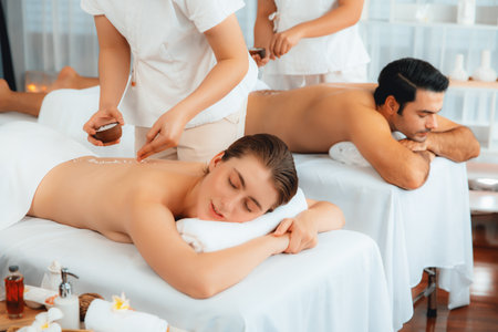 Woman customer having exfoliation treatment in luxury spa salon with warmth candle light ambient. Salt scrub beauty treatment in health spa body scrub. Quiescentの写真素材