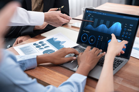 Multiracial analyst team use BI Fintech software to analyze financial data on meeting table. Financial dashboard data display on laptop screen with analyzed chart for marketing indication. Concordの写真素材