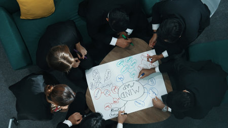 Top view of skilled diverse business people planning project by using mind map to brainstorm marketing idea. Smart start up team working together to draw mind map. Creative workplace. Directorate.の写真素材