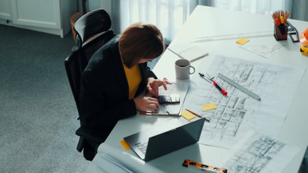 Top view of smart civil engineer drawing and measuring blueprint by using ruler. Aerial view of...