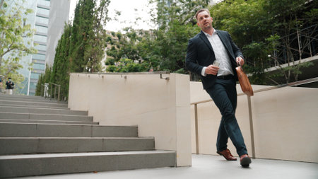 Worried smart business man running up stairs with hurry at green eco city. Anxious project manager...