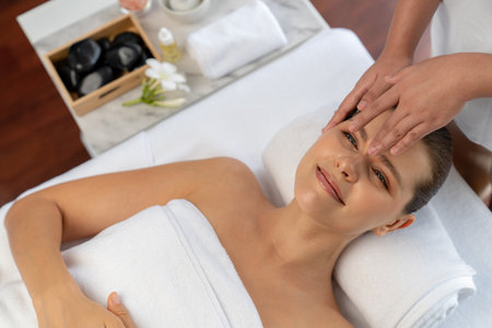 Panorama top view of woman enjoying relaxing anti-stress head massage and pampering facial beauty skin recreation leisure in dayspa modern light ambient at luxury resort or hotel spa salon. Quiescentの写真素材