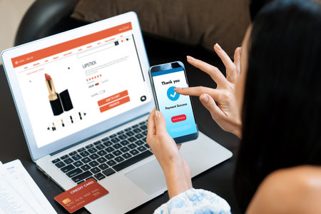 Young woman order or purchase product on internet using laptop and make transaction payment by...