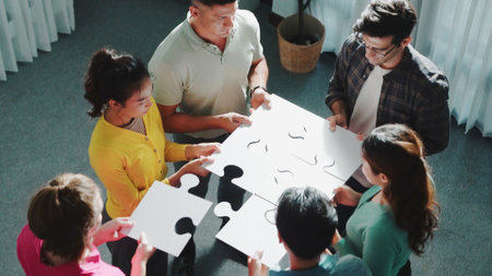 Top view of smart business people put last piece of jigsaw puzzle together to complete puzzle and standing while wearing casual cloth. Group of diverse team finding solution with teamwork. Symposium.の写真素材