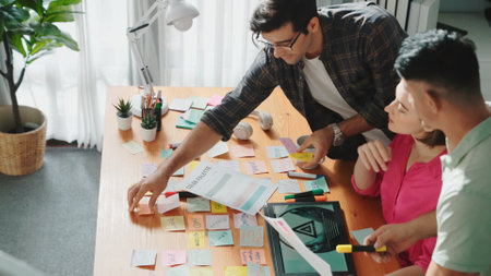 Top view of smart designer holding color palette while project manager looking at design and choosing color for program. Professional businesswoman taking a note while design creative logo. Symposium.の写真素材