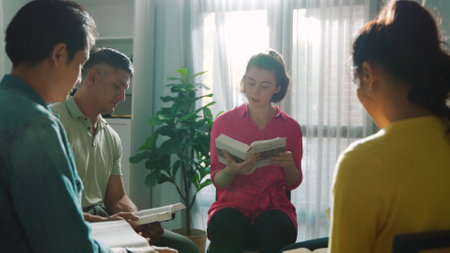 Top view of smart prayers reading bible with cross on the laps while making folded hands. Aerial view of diverse people praying to god with faith, trust and hope. and sitting in circle. Symposium.の写真素材