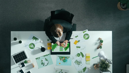 Top view of smart manager making decision about green business investment. Aerial view of skilled business woman working at meeting table with document about green energy and zero waste. Alimentation.の写真素材