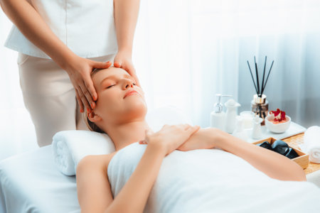 Caucasian woman enjoying relaxing anti-stress head massage and pampering facial beauty skin recreation leisure in dayspa modern light ambient at luxury resort or hotel spa salon. Quiescentの写真素材