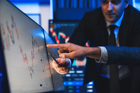 Stock traders pointing highest stock market on dynamic valued analysis on monitor real time screen,...