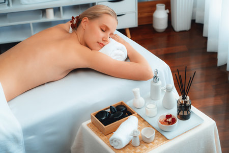 Caucasian woman customer enjoying relaxing anti-stress spa massage and pampering with beauty skin recreation leisure in day light ambient salon spa at luxury resort or hotel. Quiescentの写真素材