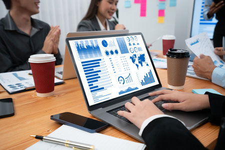 Multiracial analyst team use BI Fintech software to analyze financial data on meeting table....